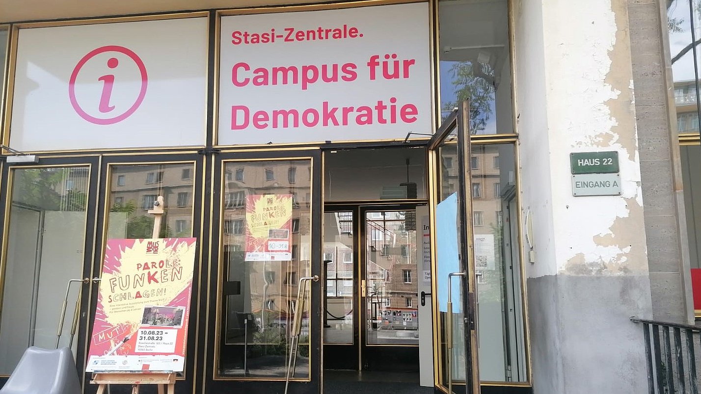 Eine Eingangstür zur Ausstellung Stasizentrale mit vielen Plakaten.