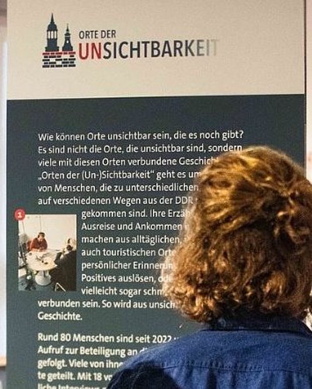 Besucherin ließt einen Info-Tafel.